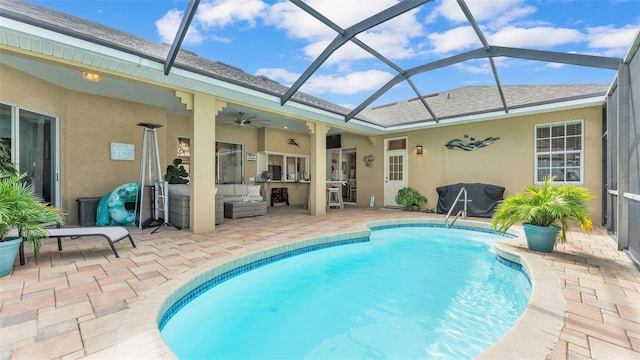 view of swimming pool with outdoor lounge area, a patio, ceiling fan, and glass enclosure