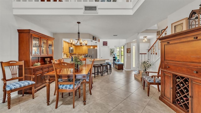 dining room with visible vents, a notable chandelier, stairway, and light tile patterned floors