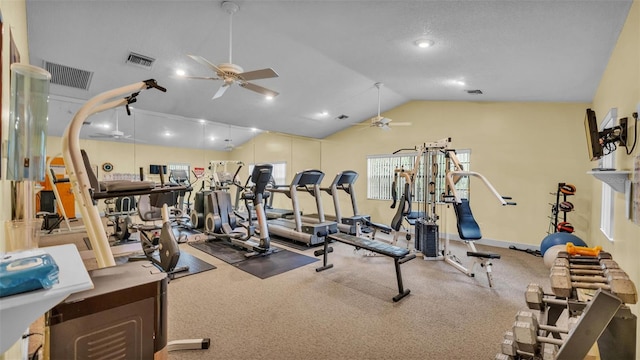 exercise room with visible vents, vaulted ceiling, and ceiling fan