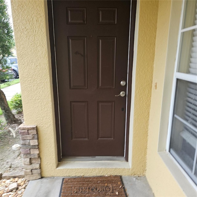 view of exterior entry with stucco siding