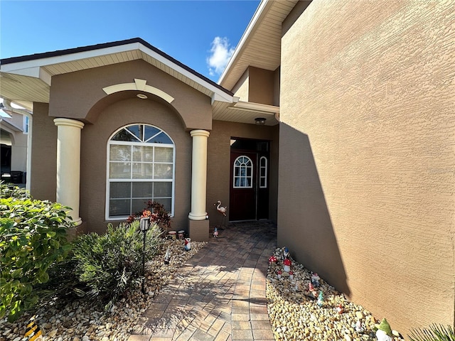 doorway to property featuring stucco siding