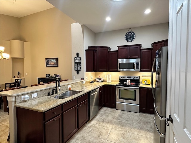 394 Nolane Ln, Polk City, FL 33868 - kitchen with a peninsula, light stone countertops, stainless steel appliances, and a sink