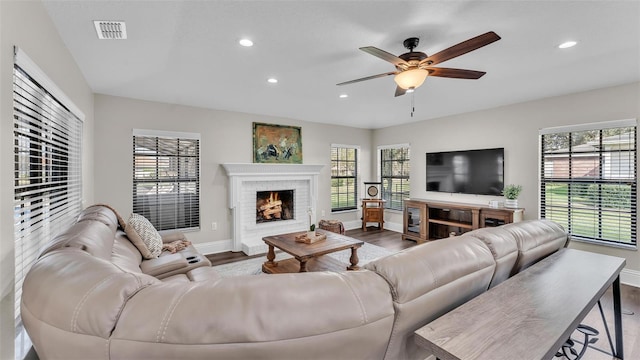 living area featuring a wealth of natural light, visible vents, and wood finished floors