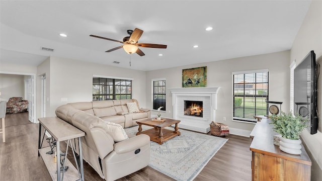 living area featuring dark wood-style floors, recessed lighting, visible vents, a brick fireplace, and ceiling fan