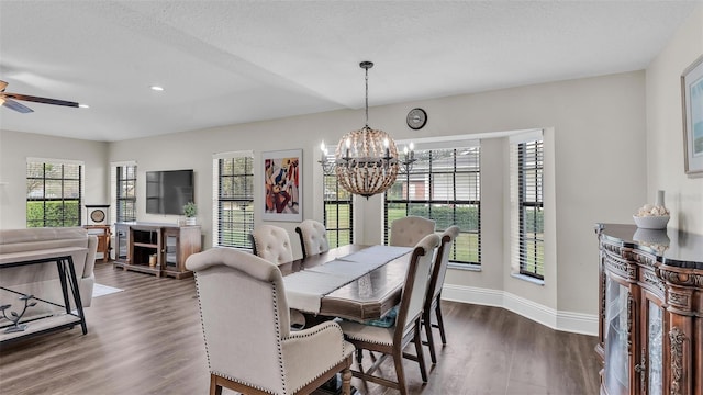 dining space with dark wood-style floors, baseboards, a textured ceiling, and ceiling fan with notable chandelier