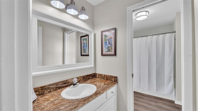 full bath featuring vanity and wood finished floors