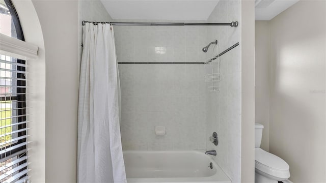 full bathroom featuring toilet and shower / tub combo with curtain