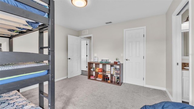 carpeted bedroom featuring baseboards and visible vents