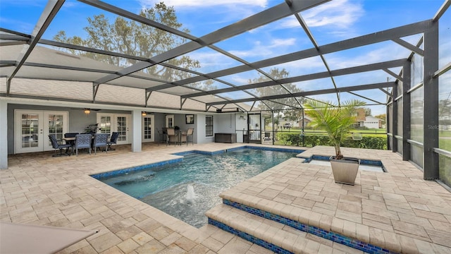 outdoor pool featuring ceiling fan, glass enclosure, a jacuzzi, french doors, and a patio area