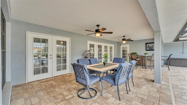 view of patio / terrace with a ceiling fan, outdoor dining space, french doors, and exterior bar