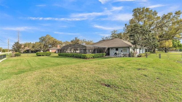 exterior space featuring glass enclosure, a lawn, and a fenced backyard