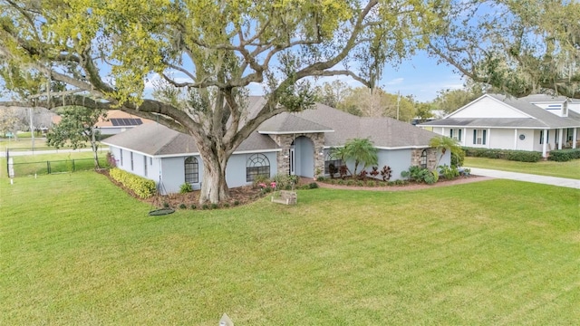 single story home featuring driveway, fence, and a front yard