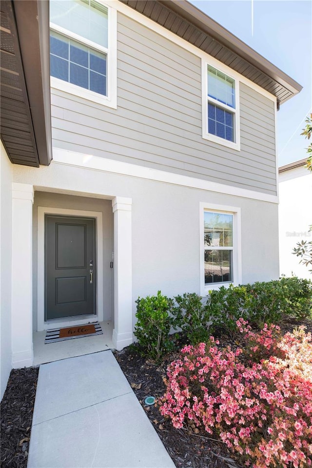 view of exterior entry with stucco siding