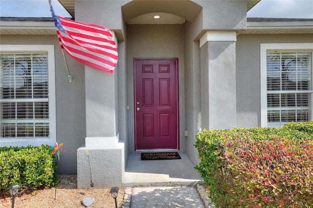 view of exterior entry with stucco siding