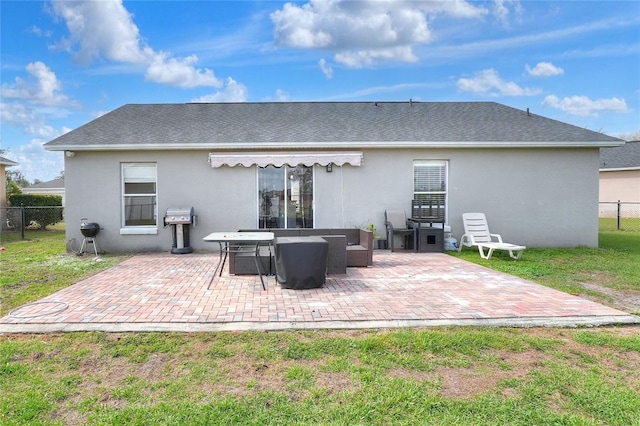 rear view of house featuring stucco siding, a yard, fence, and a patio