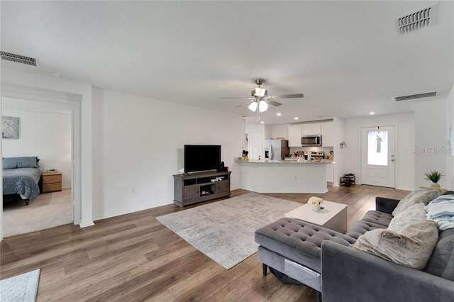 living area with light wood-style floors, recessed lighting, and visible vents