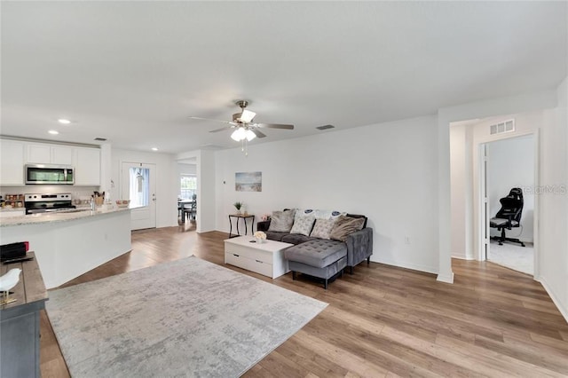 living room featuring recessed lighting, visible vents, ceiling fan, and light wood finished floors