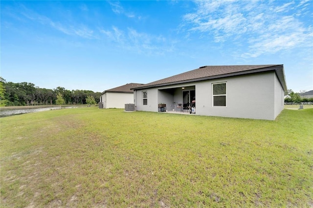 rear view of property featuring a patio area, central AC, a lawn, and stucco siding