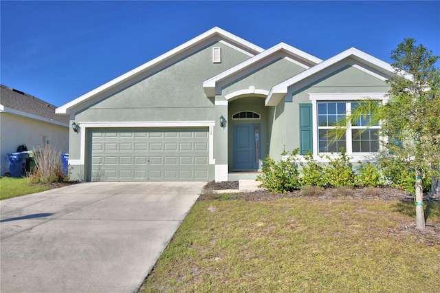 single story home with a front yard, concrete driveway, an attached garage, and stucco siding