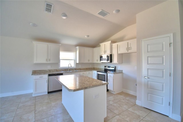 kitchen with a sink, a kitchen island, white cabinetry, light countertops, and appliances with stainless steel finishes