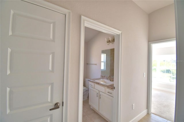 bathroom with tile patterned flooring, baseboards, vanity, and toilet