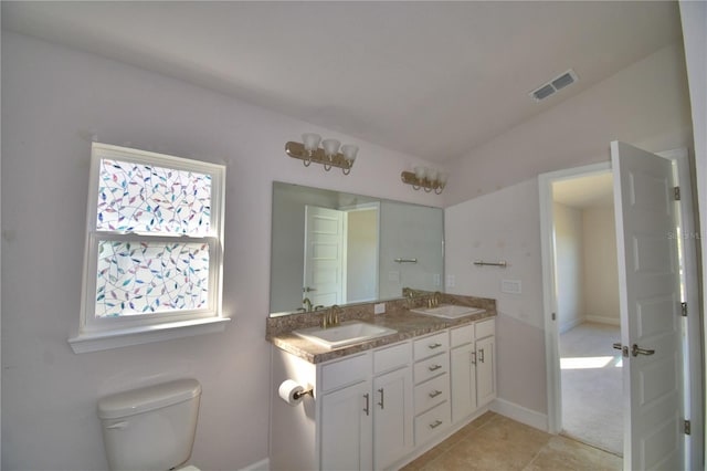 full bath featuring toilet, double vanity, a sink, and visible vents