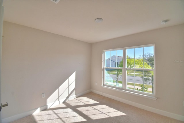 empty room with light carpet and baseboards