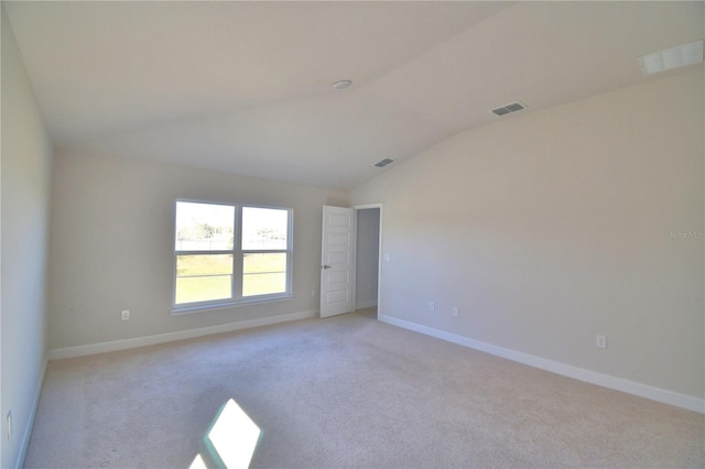 unfurnished room featuring light carpet, baseboards, visible vents, and vaulted ceiling