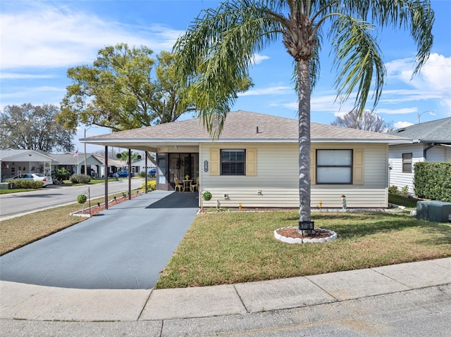 view of front of house featuring driveway, a front lawn, a shingled roof, and an attached carport