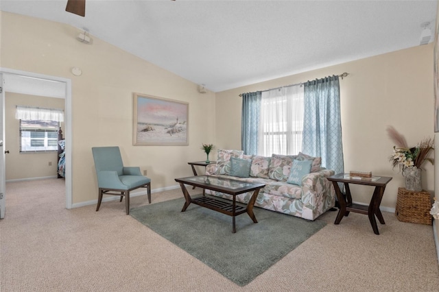 living area with carpet floors, baseboards, and vaulted ceiling