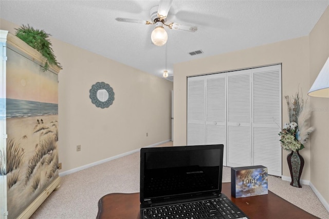 interior space with baseboards, ceiling fan, visible vents, and a textured ceiling