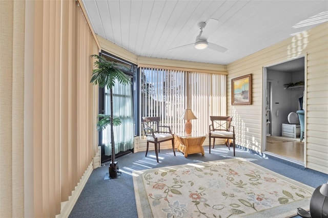 living area with ceiling fan, dark colored carpet, and a wealth of natural light