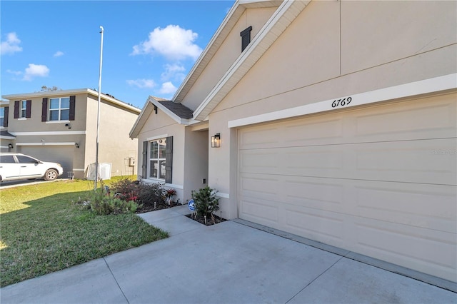 view of property exterior with a yard, driveway, an attached garage, and stucco siding