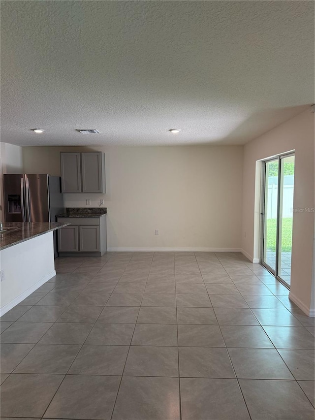 6769 SE 3rd Loop, Ocala, FL 34472 - unfurnished living room with a textured ceiling, light tile patterned floors, and recessed lighting