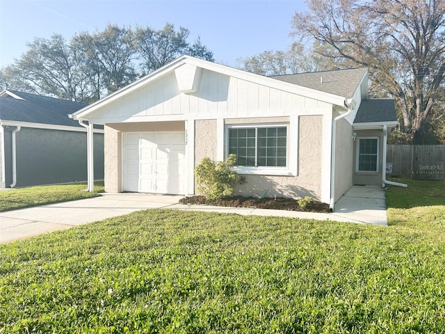 view of front of property featuring a garage, concrete driveway, fence, and a front lawn