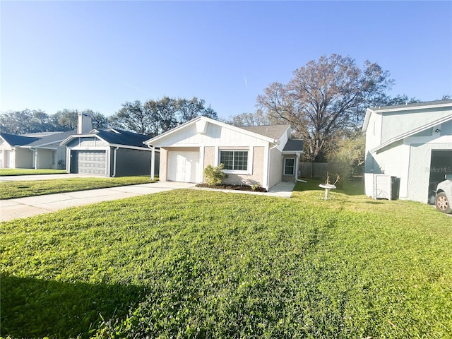 view of front of property with an attached garage, fence, a front lawn, and concrete driveway