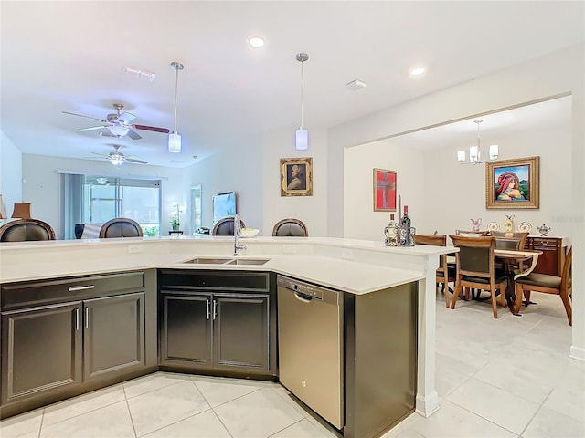 kitchen with decorative light fixtures, light tile patterned floors, light countertops, a sink, and dishwasher