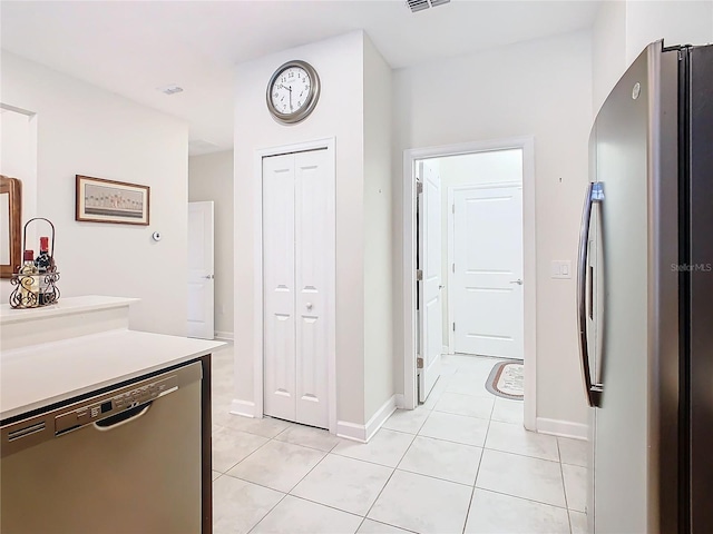 kitchen with light tile patterned floors, visible vents, stainless steel appliances, and light countertops