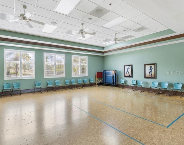 interior space featuring a healthy amount of sunlight, a paneled ceiling, and a ceiling fan