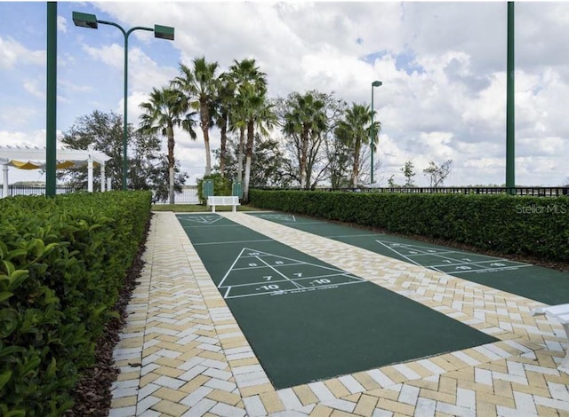 view of community featuring shuffleboard and a pergola