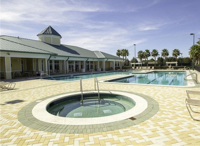 pool with a hot tub and a patio