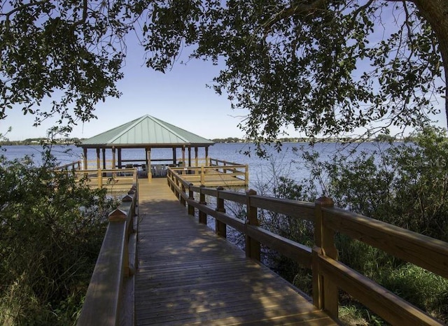 view of dock with a gazebo and a water view