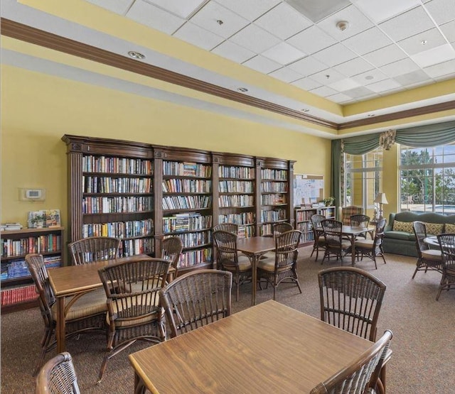 carpeted dining area featuring a drop ceiling