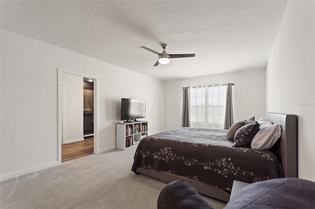 bedroom featuring light carpet, ceiling fan, a textured ceiling, and baseboards