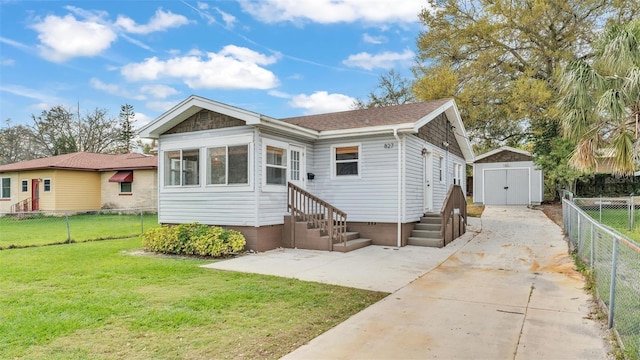 view of front of home with entry steps, an outbuilding, a fenced backyard, a storage unit, and a front lawn