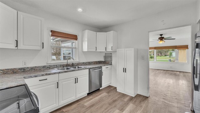 kitchen featuring dishwasher, light wood-style flooring, black / electric stove, white cabinetry, and a sink