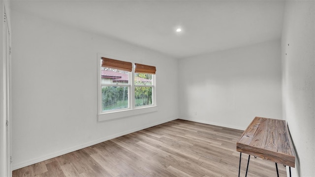 unfurnished room featuring recessed lighting, wood finished floors, and baseboards