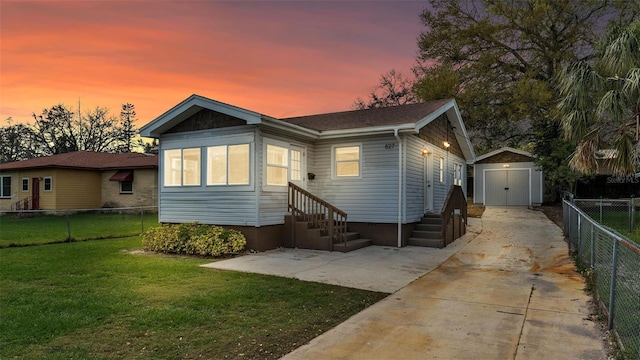 view of front of property featuring entry steps, a storage unit, fence, an outdoor structure, and a front yard