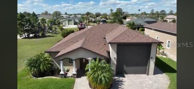 view of front of property with a front lawn, a residential view, driveway, and an attached garage