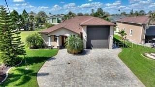 view of front of house featuring driveway, a garage, and a front lawn